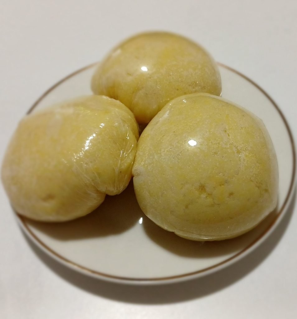 Fufu corn in a white dish on a white background.