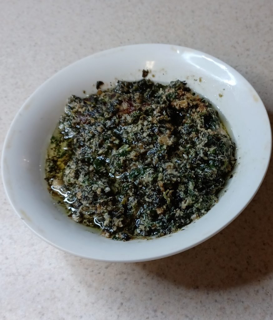 Ndole in a white bowl on a white background.