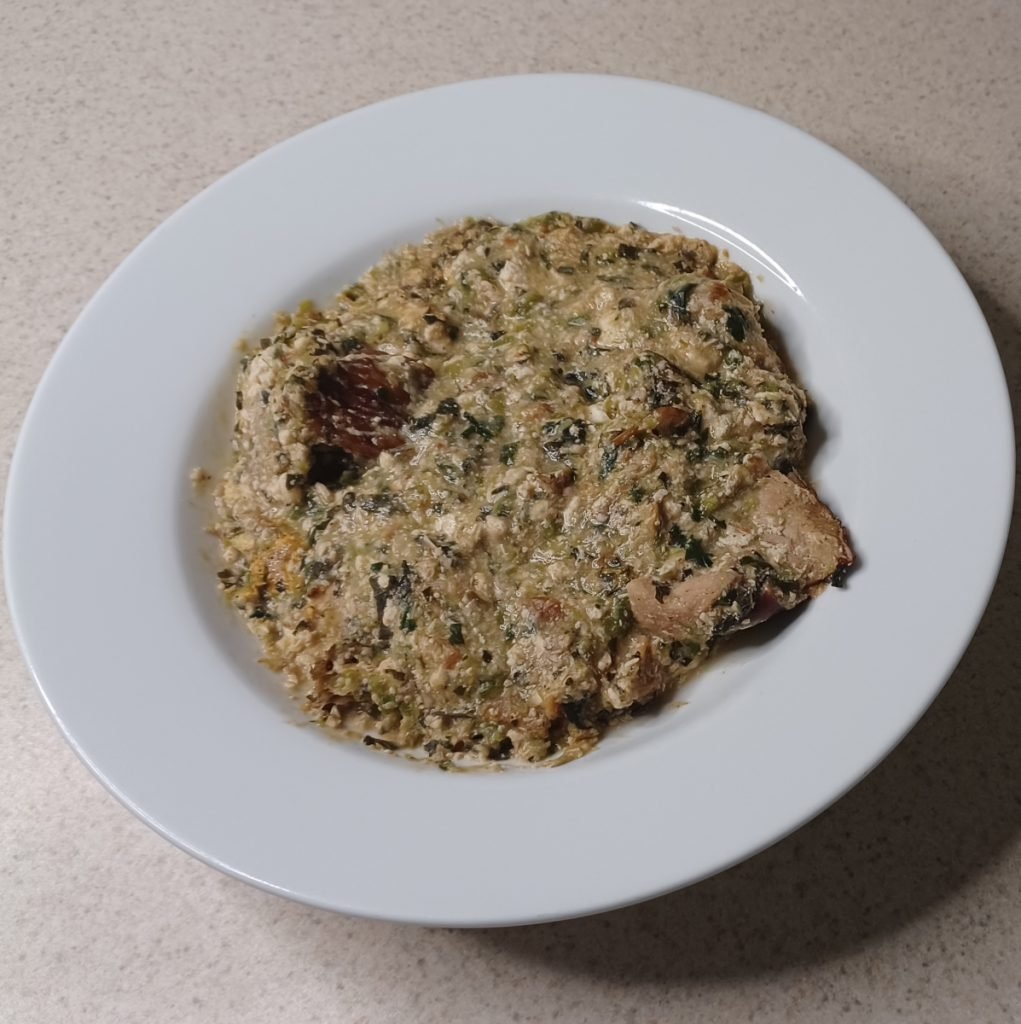 Okro soup in a white dish on a white kitchen slab.