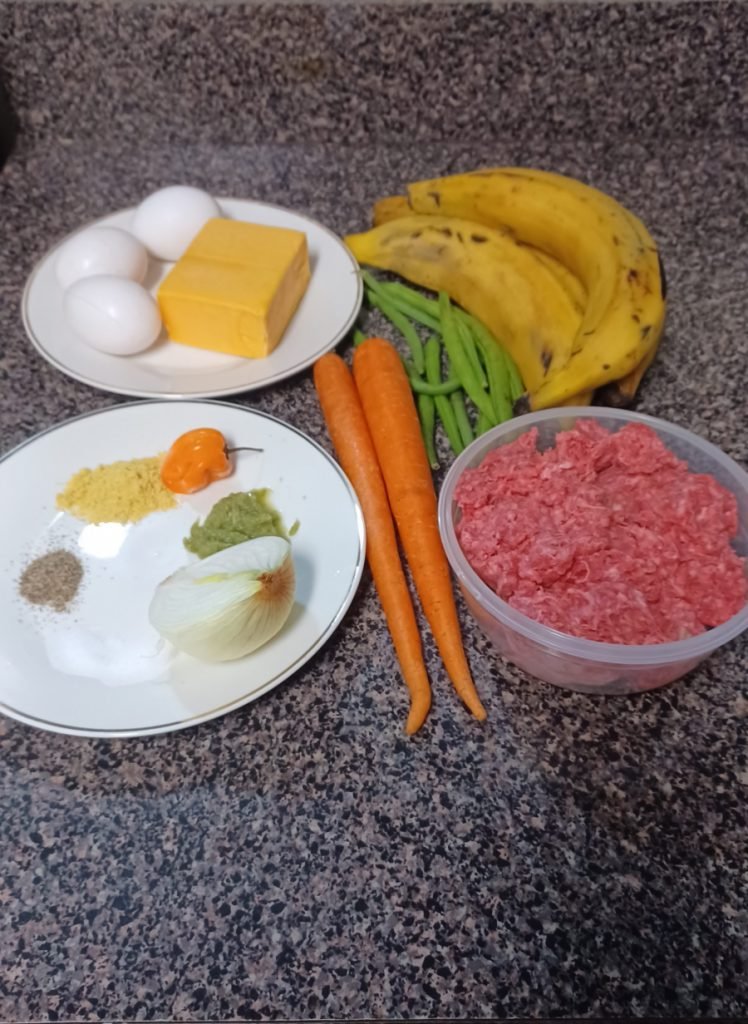 Ingredients for plantain cupcake meat pie on a gray kitchen slab.