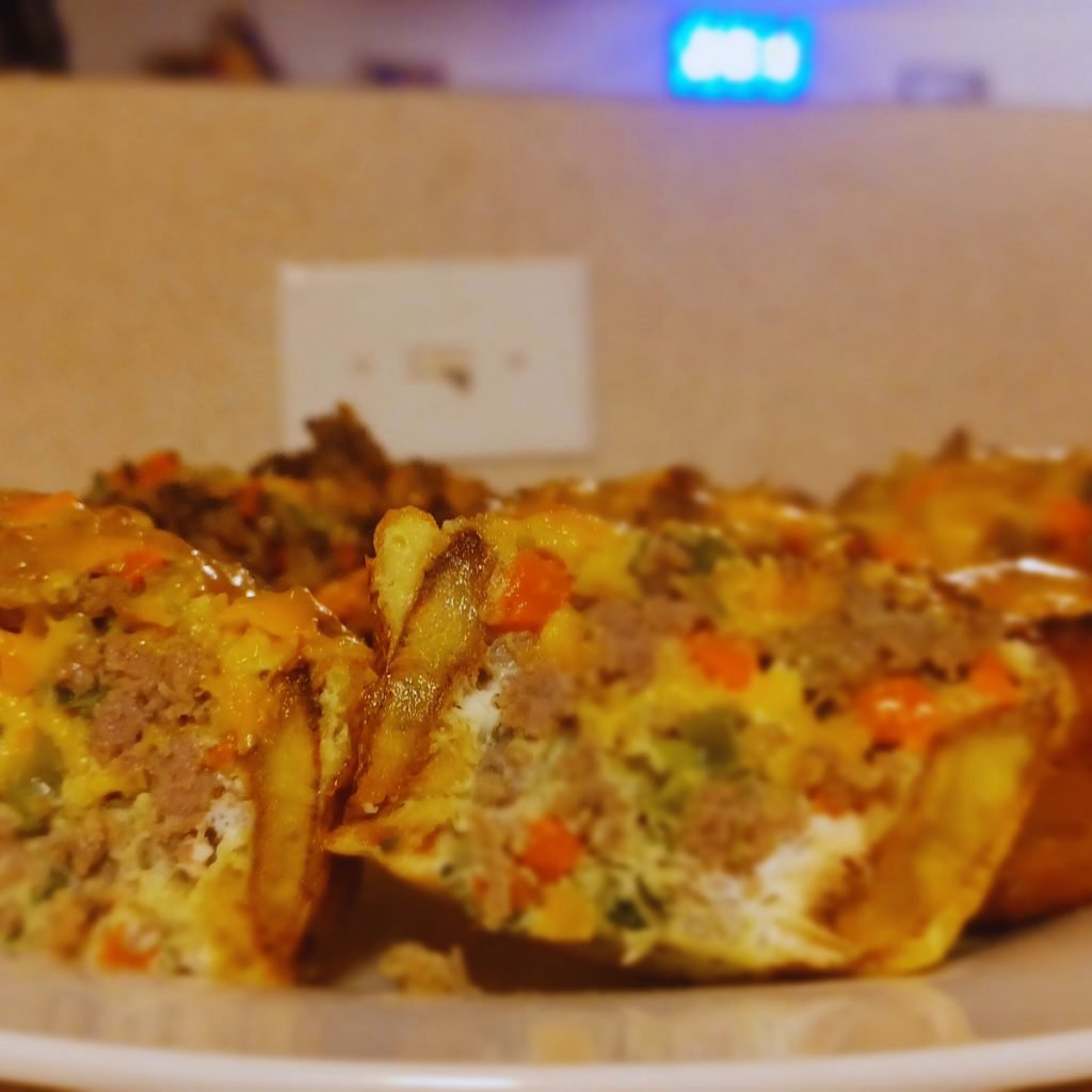 Plantain cupcake meat pie cut in halves on a white plate.
