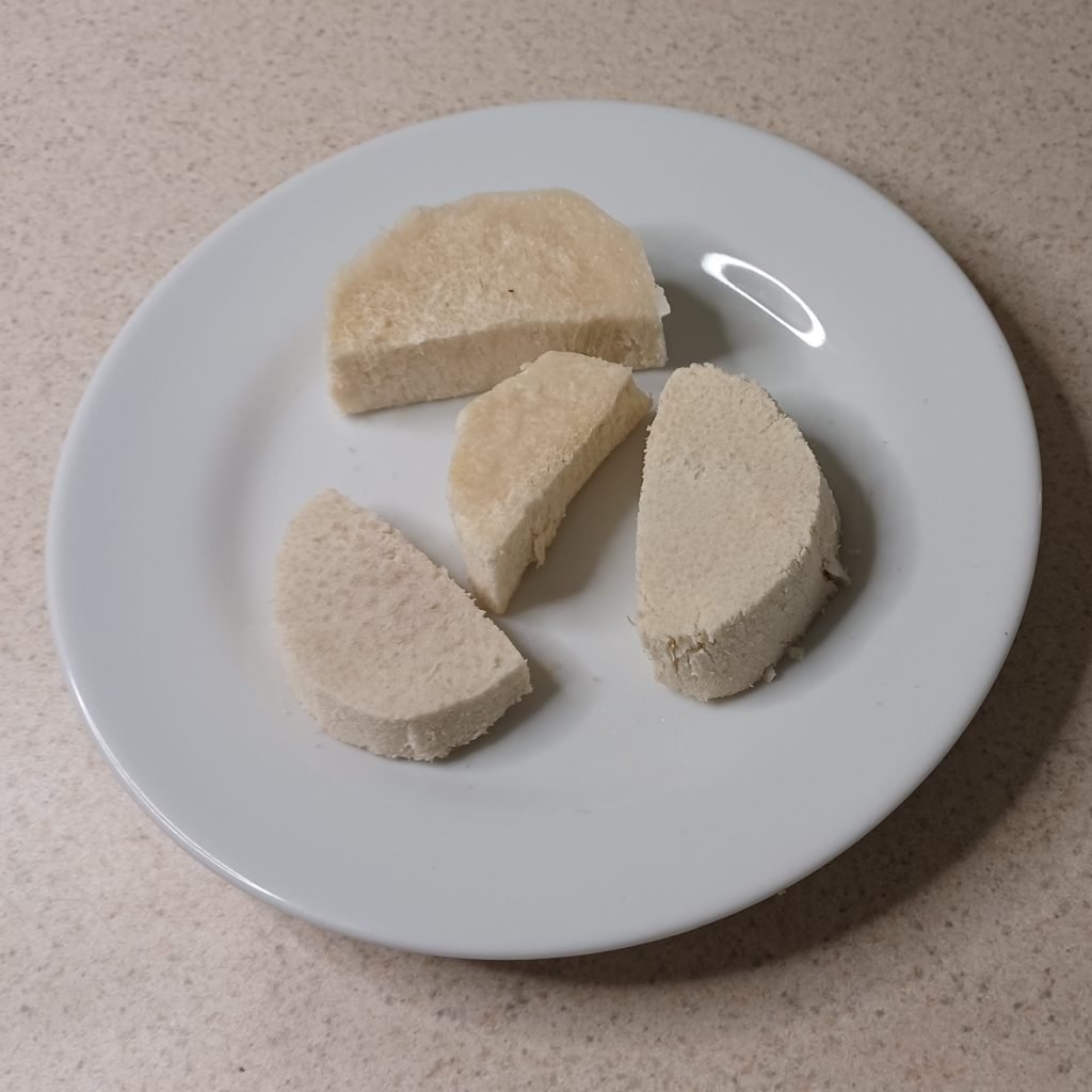 Slices of yam in a white dish on a white kitchen slab.
